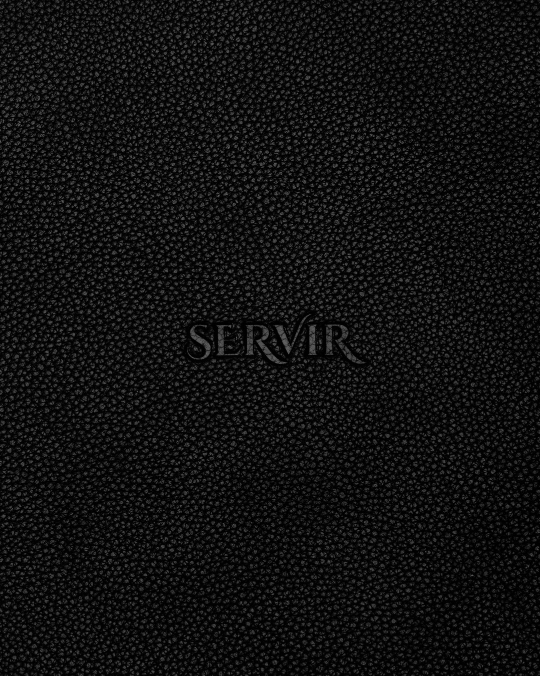 Debossed SERVIR logo on black recycled leather placemat reverse — leather grain texture detail