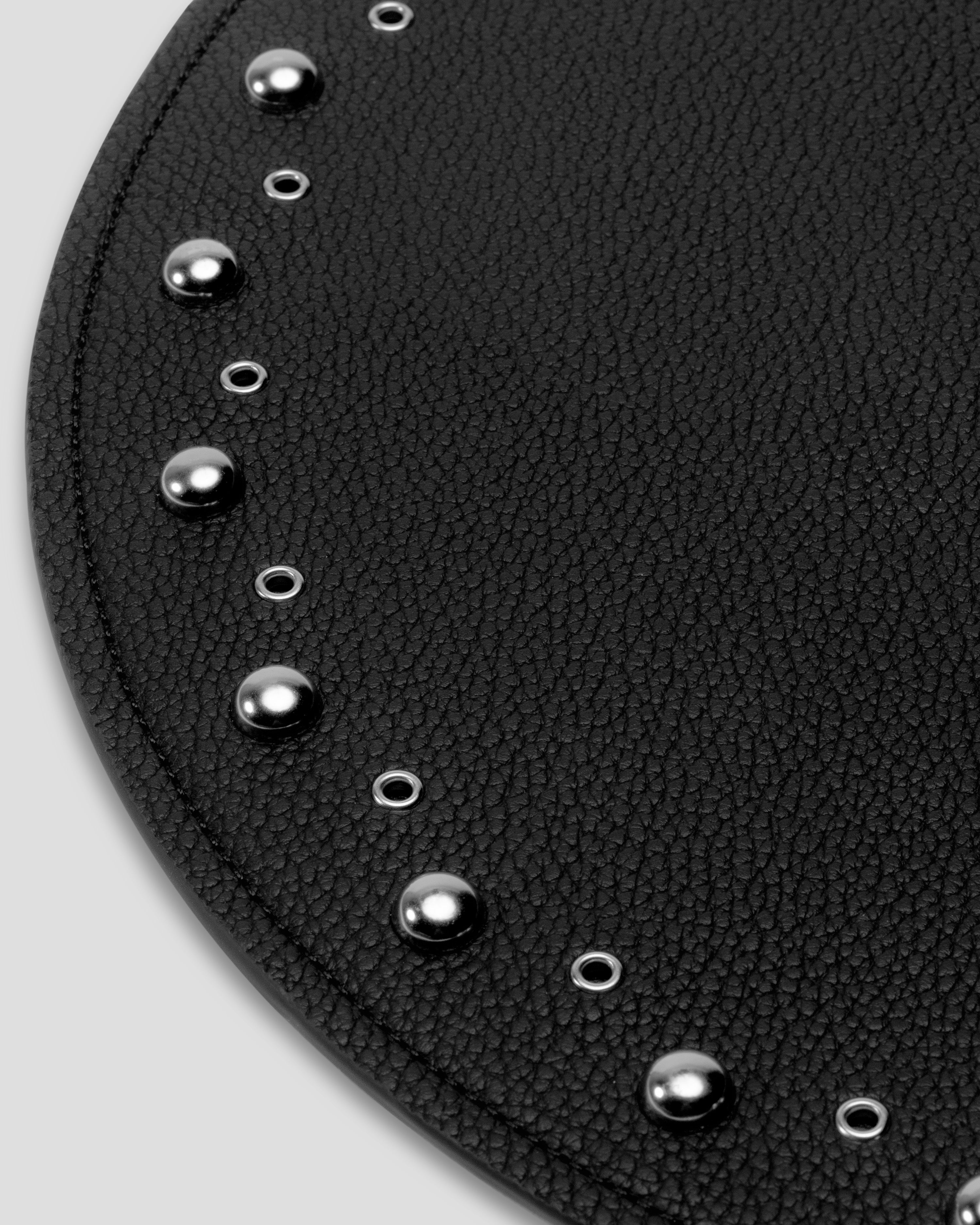 Close-up detail of silver dome studs and open eyelets on black recycled leather placemat — SERVIR hand-embellished hardware